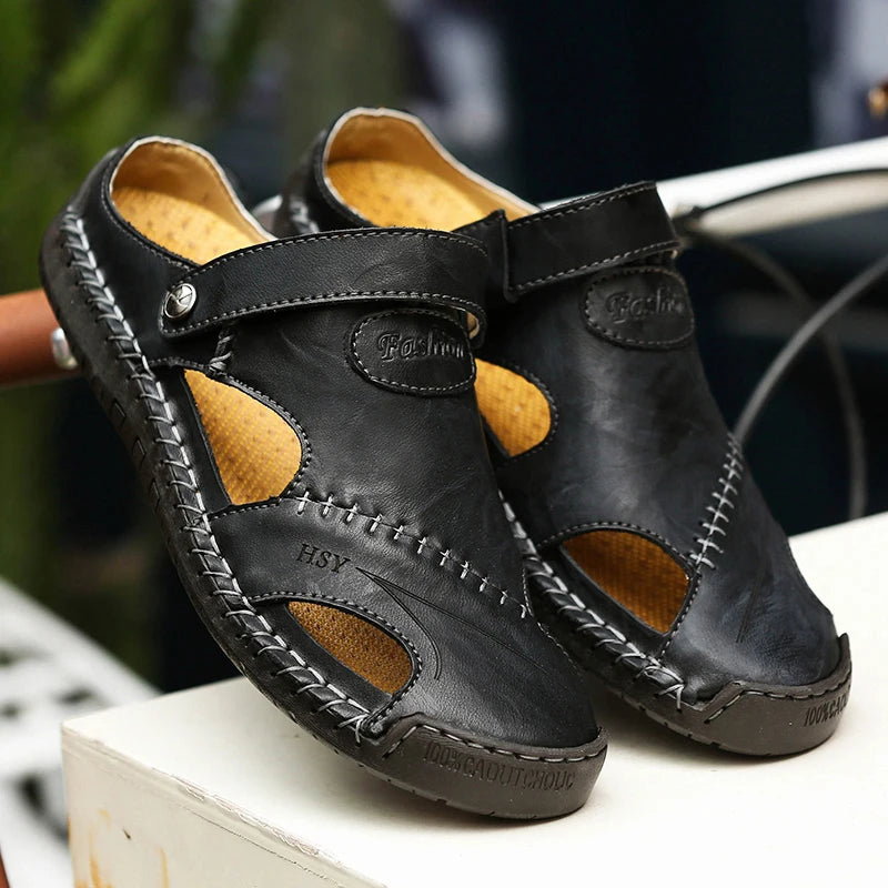 Pair of black leather sandals with brown accents on a white surface.